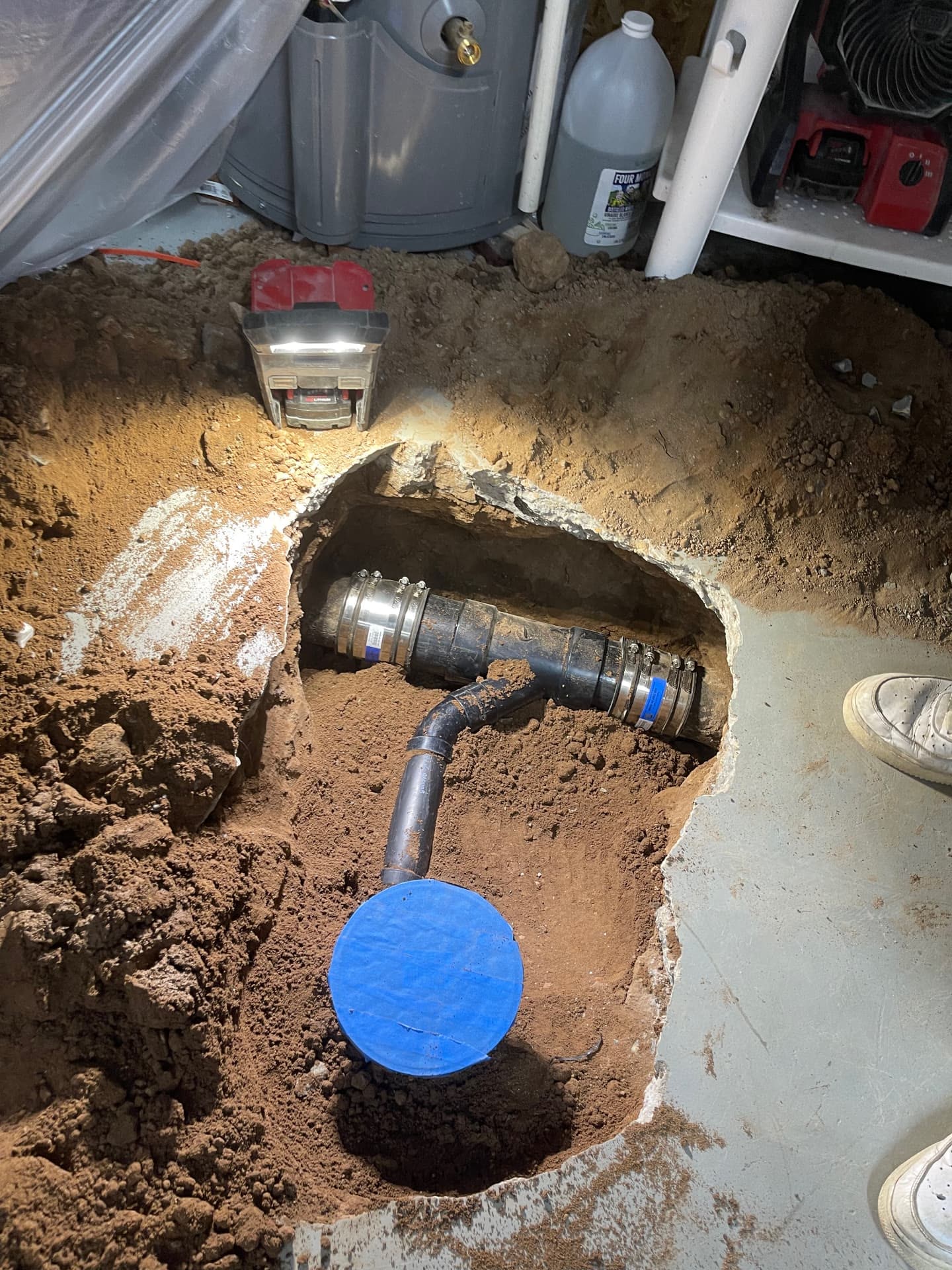 New PVC tee and cleanout set in a concrete slab cut inside a home